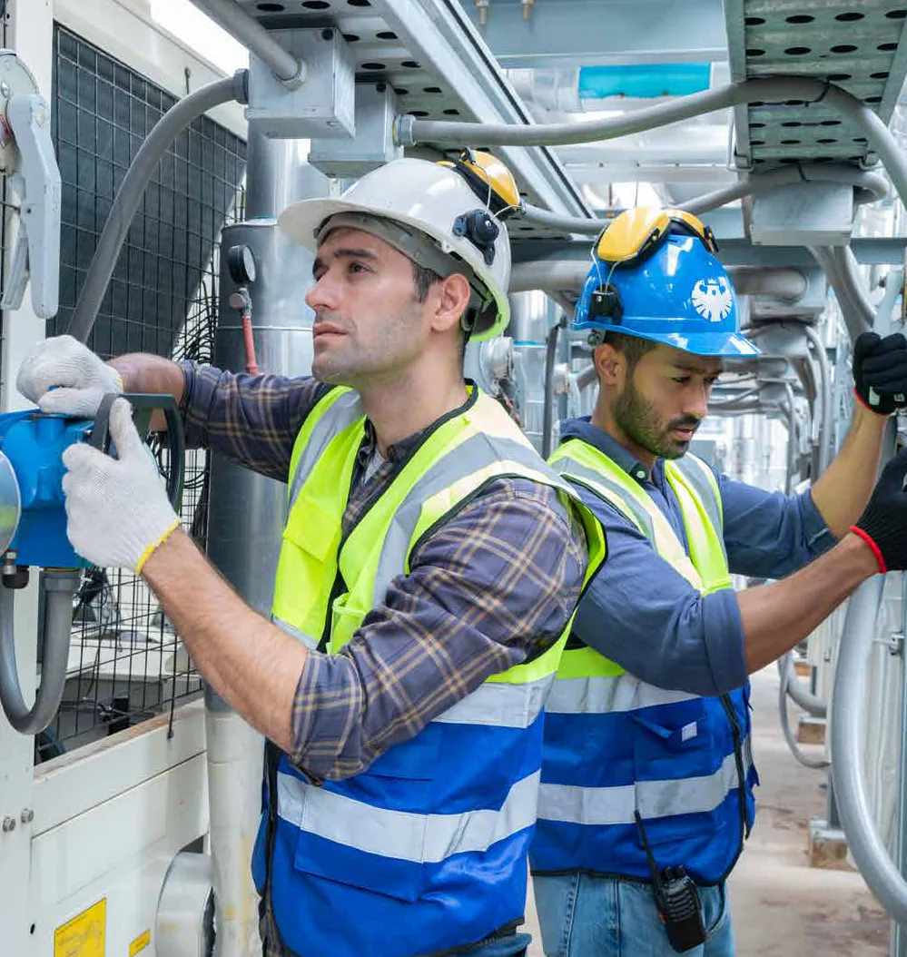 Two technicians working on a duct installation
