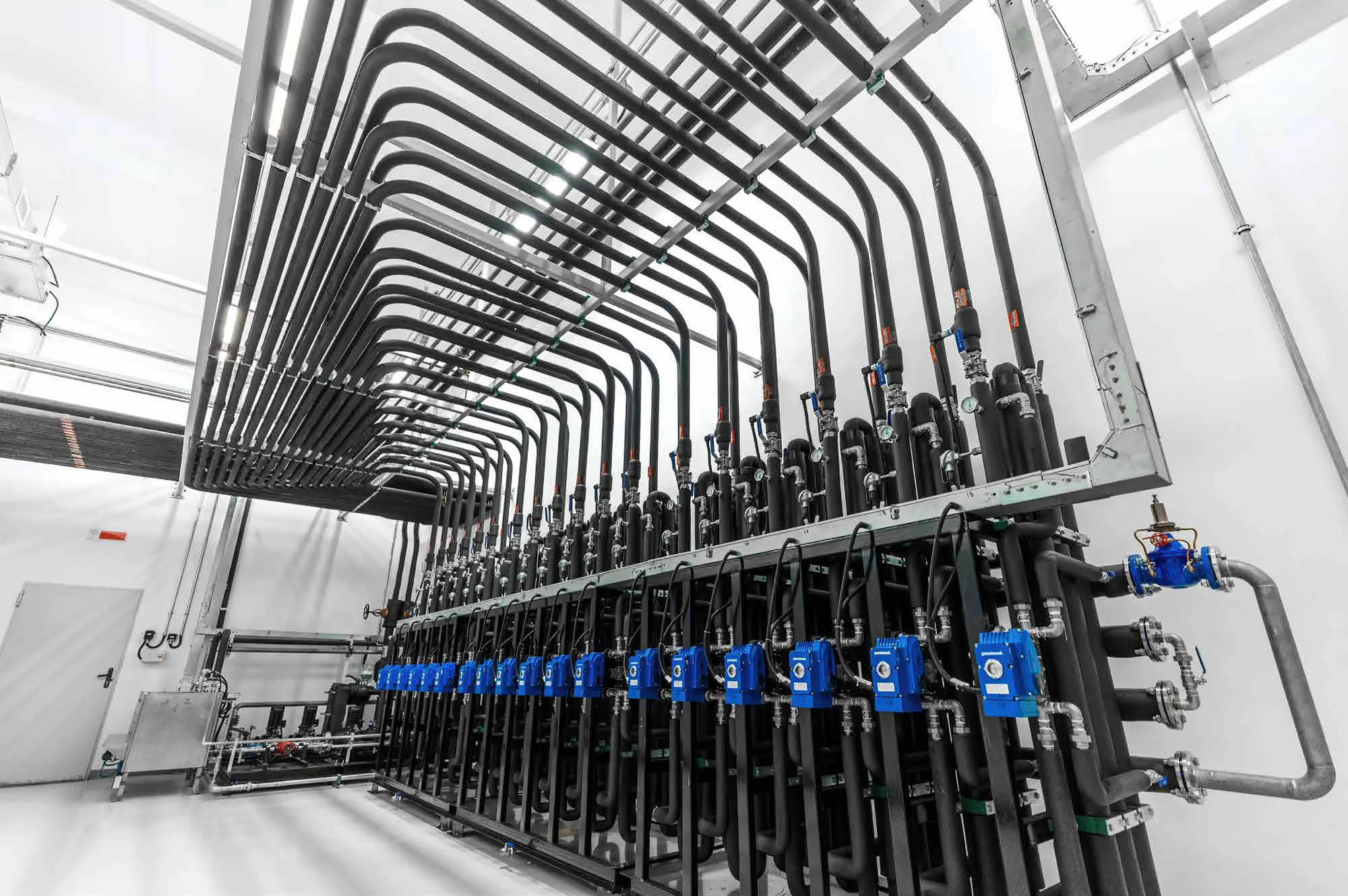 Pipe manifold with blue actuators in a plant room